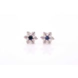 A pair of diamond and sapphire floral cluster earrings, set in white metal mounts, the yellow