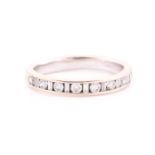 An 18ct white gold and diamond half eternity ring, channel-set with alternating round and baguette-