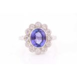 An 18ct white gold, diamond, and tanzanite cluster ring, set with a mixed oval-cut tanzanite of