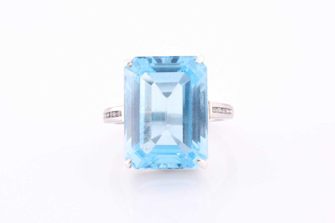 A platinum, blue topaz and diamond dress ring, set with a mixed rectangular-cut topaz, of