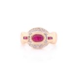A 9k yellow gold and ruby ring, set with a mixed oval-cut ruby, the stylised mount inset with