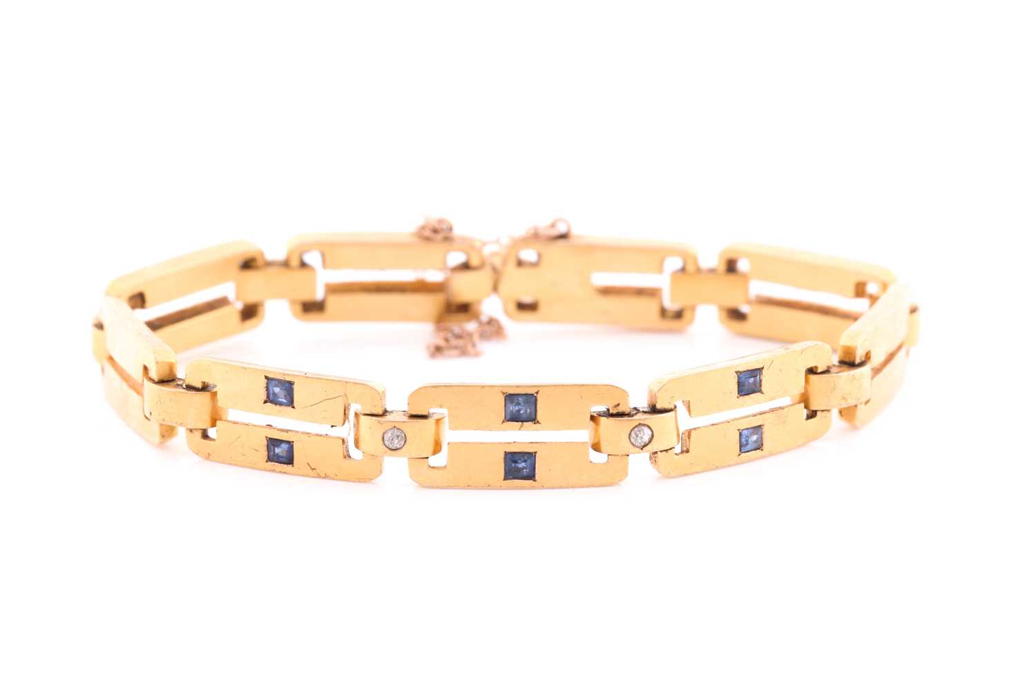 A yellow metal, diamond and sapphire bracelet, comprised of articulated bar links, the three