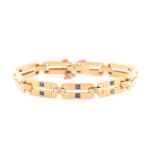 A yellow metal, diamond and sapphire bracelet, comprised of articulated bar links, the three