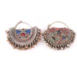 A pair of Eastern white metal and paste stone earrings, one with red, blue, and green paste