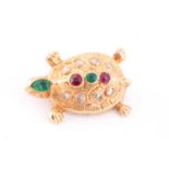 A yellow metal novelty brooch in the form of a turtle, inset with a pear-cut emerald to the head,