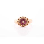 An 18ct yellow gold, diamond, and ruby floral cluster ring, the claw-raised mount pave-set with