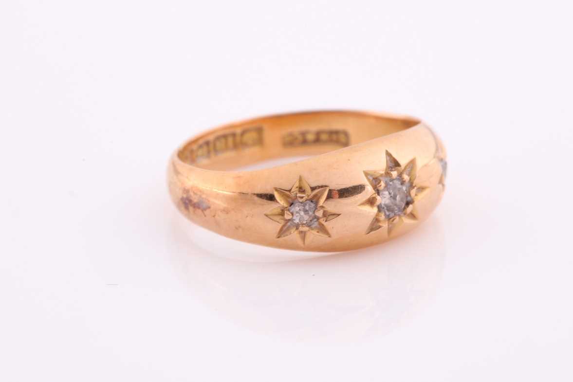 A three stone gypsy set ring, the graduated old brilliant cut diamonds in tapering 18 carat rose - Image 4 of 5