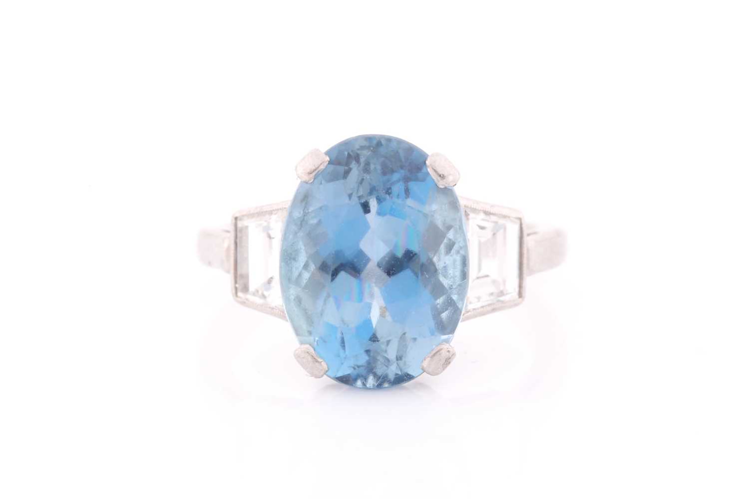 A diamond and blue topaz ring, set with a mixed oval-cut topaz, measuring approximately 12 x 8.5 mm,