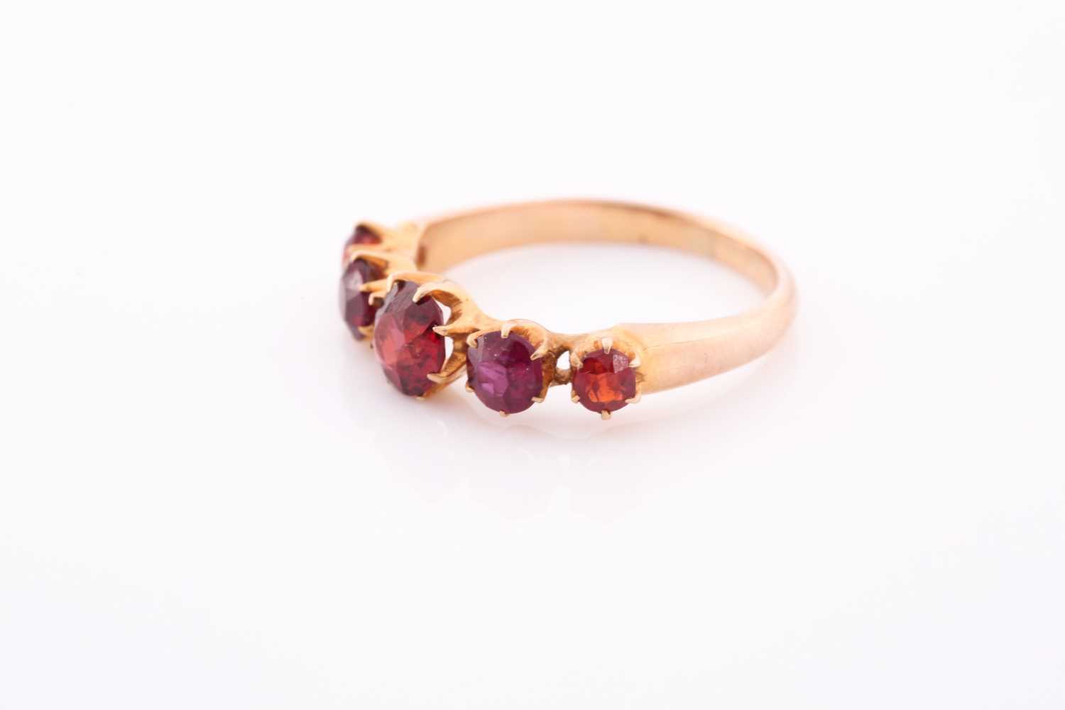 A yellow metal and garnet ring, the five round-cut garnets individually claw-set, yellow metal - Image 3 of 5