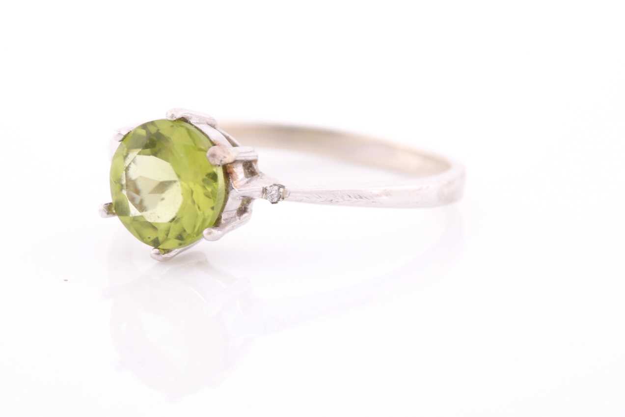 A peridot and diamond ring, centred with a mixed round-cut peridot, approximately 7.6 mm diameter, - Image 3 of 4