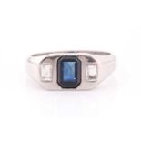 A diamond and sapphire ring, set with a mixed rectangular-cut sapphire, flanked with two modified