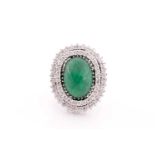 A diamond and emerald cocktail ring, circa 1960s, centred with an oval cabochon emerald, measuring