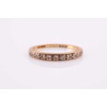 An 18ct yellow gold band ring, pave-set with small round-cut diamonds, size O, 2 grams.