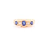 An 18ct yellow gold, diamond, and synthetic sapphire ring, set with three mixed oval-cut sapphires