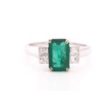 A white gold, diamond, and emerald ring, set with a mixed emerald-cut emerald, of approximately 1.70