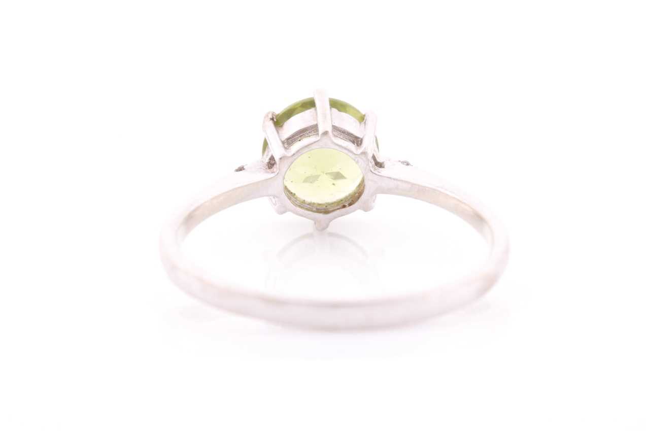 A peridot and diamond ring, centred with a mixed round-cut peridot, approximately 7.6 mm diameter, - Image 4 of 4