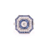 A platinum, diamond, and sapphire ring, in the Art Deco style, centred with a round-cut diamond,