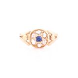 A yellow metal, diamond, and sapphire ring, set with a small round sapphire, within a border of