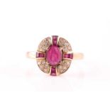 A ruby and diamond cluster ring, the central mixed oval cut ruby with a cruciform plaque of