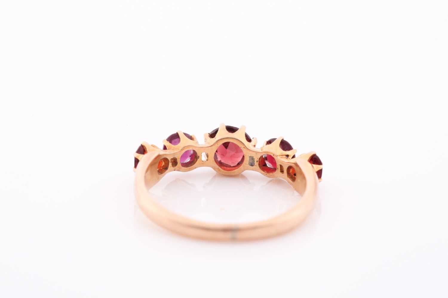 A yellow metal and garnet ring, the five round-cut garnets individually claw-set, yellow metal - Image 2 of 5