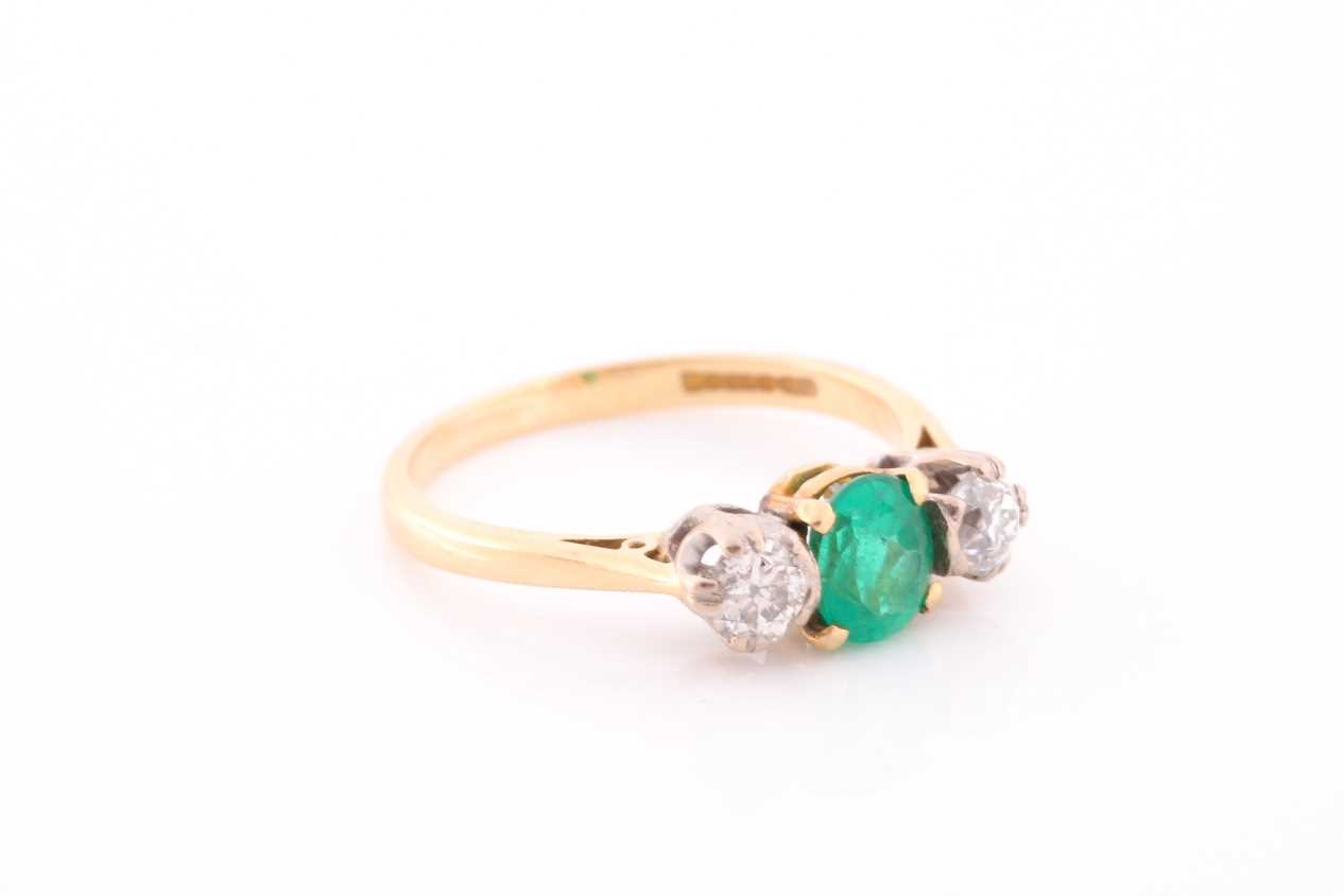 A three stone half hoop emerald and diamond ring. The oval cut emerald in four claw mount flanked by - Image 4 of 4