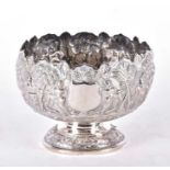 A 20th century Burmese white metal pedestal bowl typically decorated with a figures and trees in