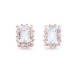 A pair of diamond and aquamarine earrings, each set with an emerald-cut aquamarine within a border
