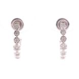 A pair of 18ct white gold and diamond earrings, each set with seven graduated floral clusters of