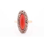 An early 20th century yellow metal, diamond, and coral ring, the navette-shaped mount inset with