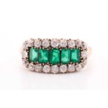 An emerald and diamond three row ring, set with a central line of slightly graduated emerald-cut