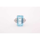 A diamond and blue topaz cocktail ring, set with a mixed rectangular-cut topaz, measuring