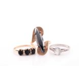 A 9ct yellow gold and black stone ring, set with a marquise-shaped stone set on a crossover mount