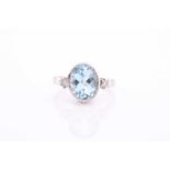 A white gold, diamond and blue stone ring, collet-set with a mixed oval-cut blue stone (likely