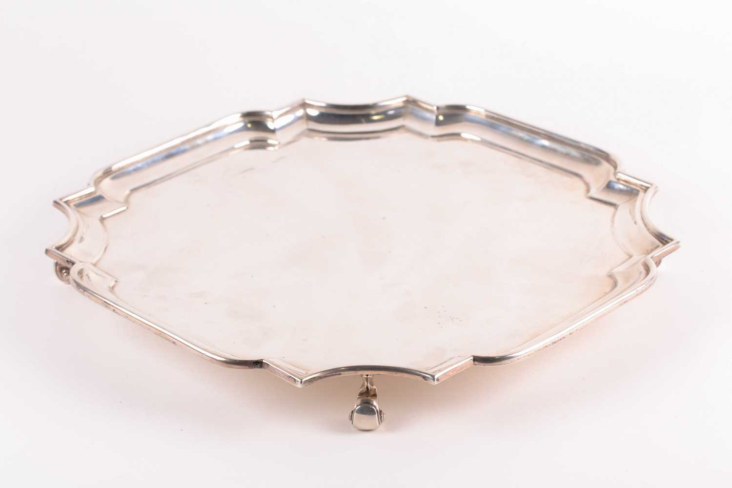 A George V silver salver, London 1920 by Z Barraclough & Sons, of shaped, square form on four scroll