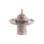 A Sino Tibetan silver metal cup stand and cover, 19th century, the cover with coral coloured glass