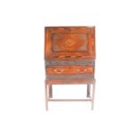 A George III vernacular oak fall front writing bureau. With carved and inlaid decoration dated