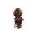 A Dan mask, Liberia/Ivory Coast, a cushioned headdress of cowrie shells and coloured glass beads,