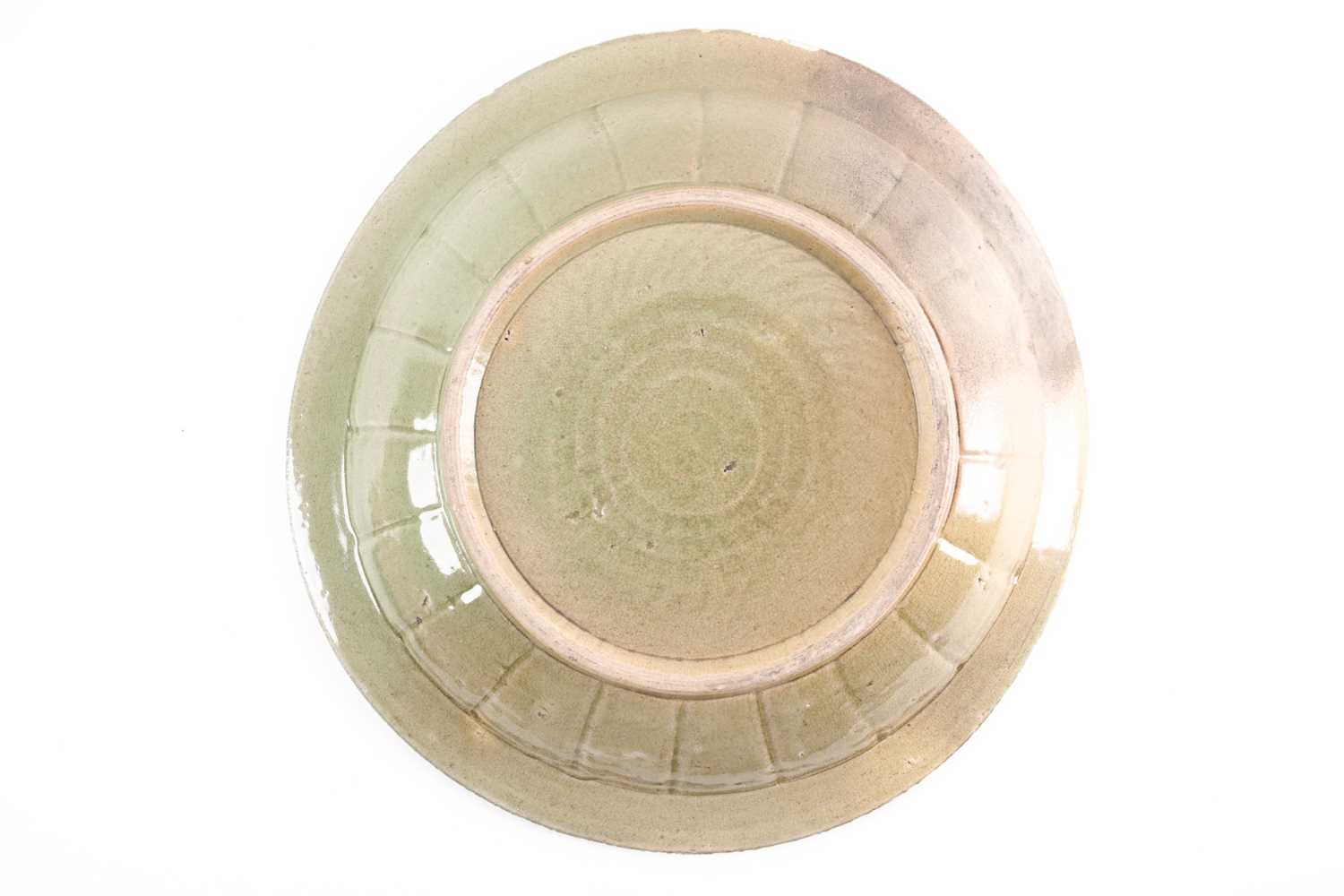 A circular celadon charger carved with a bird on a field of clouds within a stylized wave border - Image 2 of 5