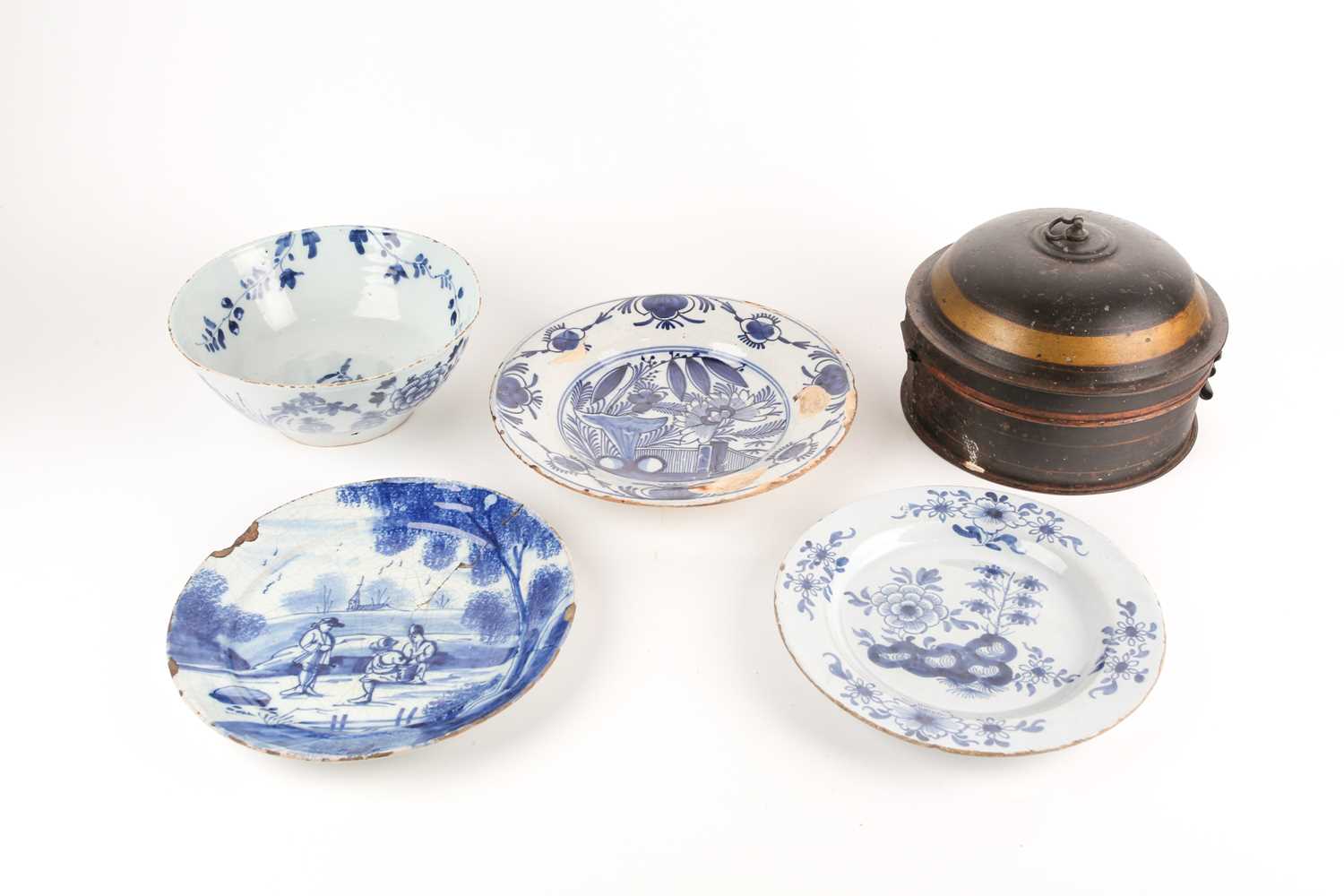 An 18th century delftware bowl and three plates, the bowl and a plate similarly decorated, painted
