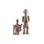 A Baule maternity figure, Ivory Coast, the smiling figure seated upon a stool and holding onto two