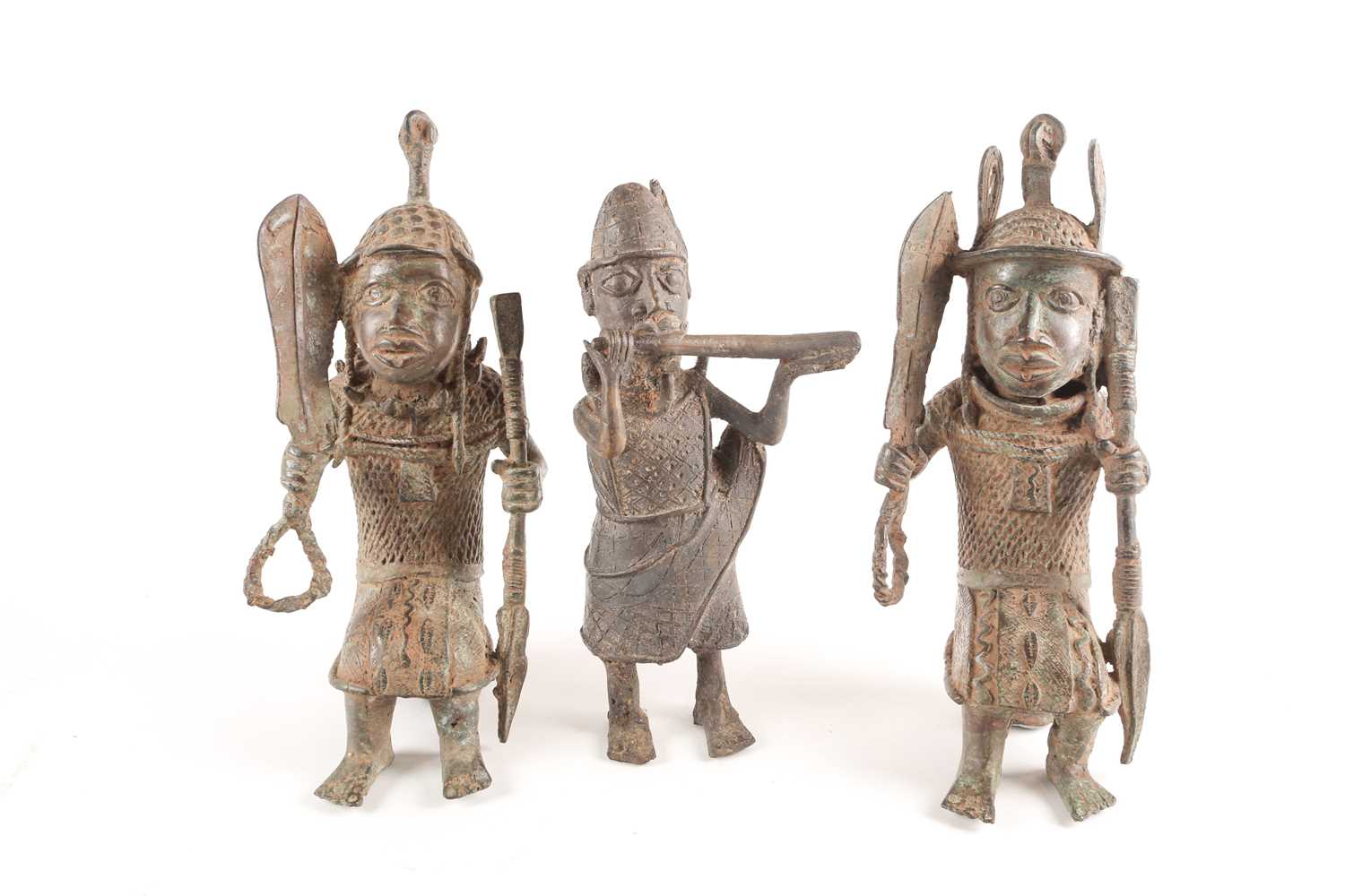 A pair near of Benin bronze seated warriors, Nigeria, each holding a sword and spear, 29.5cm & 30cm;