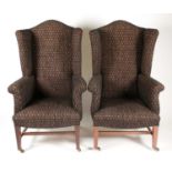 A pair of George III style wingbacked fireside chairs, C1900. With rollover arms and camelbacks.