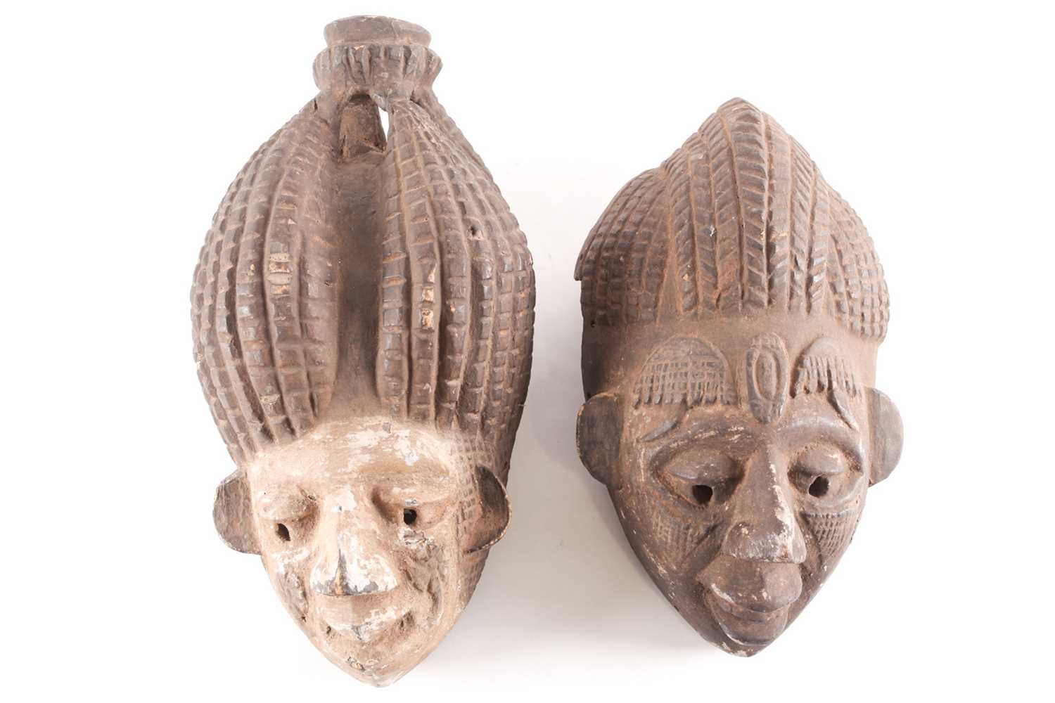 An Ibibio mask, Nigeria, with tall coiffure united at the top, the kaolin painted face with relief