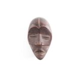 A Dan mask, Ivory Coast/Liberia, the forehead with central median, above relief carved eye brows,