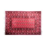 A red ground 20th-century Belgian machine knotted "Tekke" style carpet with a lattice and gul