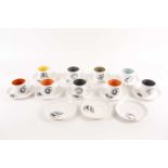 A collection of Susie Cooper black fruit pattern coffee cans and saucers, the cans with variously