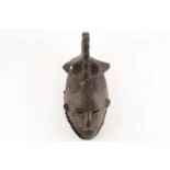 An Igbo Maiden Spirit mask, Agbogho Mmua, Nigeria, the headdress inset with two circular mirrors