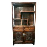 A Chinese carved and pierced rosewood cabinet, 20th century. With open upper sections above two