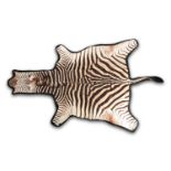 A large fabric-backed Zebra skin rug with an unblocked head. 320 cm long x 194 cm wideCondition