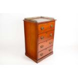 An Edwardian walnut four-drawer pedestal chest with gilt brass pierced gallery. Supported on a